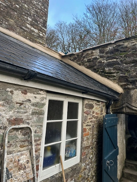 A new slate roof installation on a stone cottage in South Devon, showcasing traditional roofing.