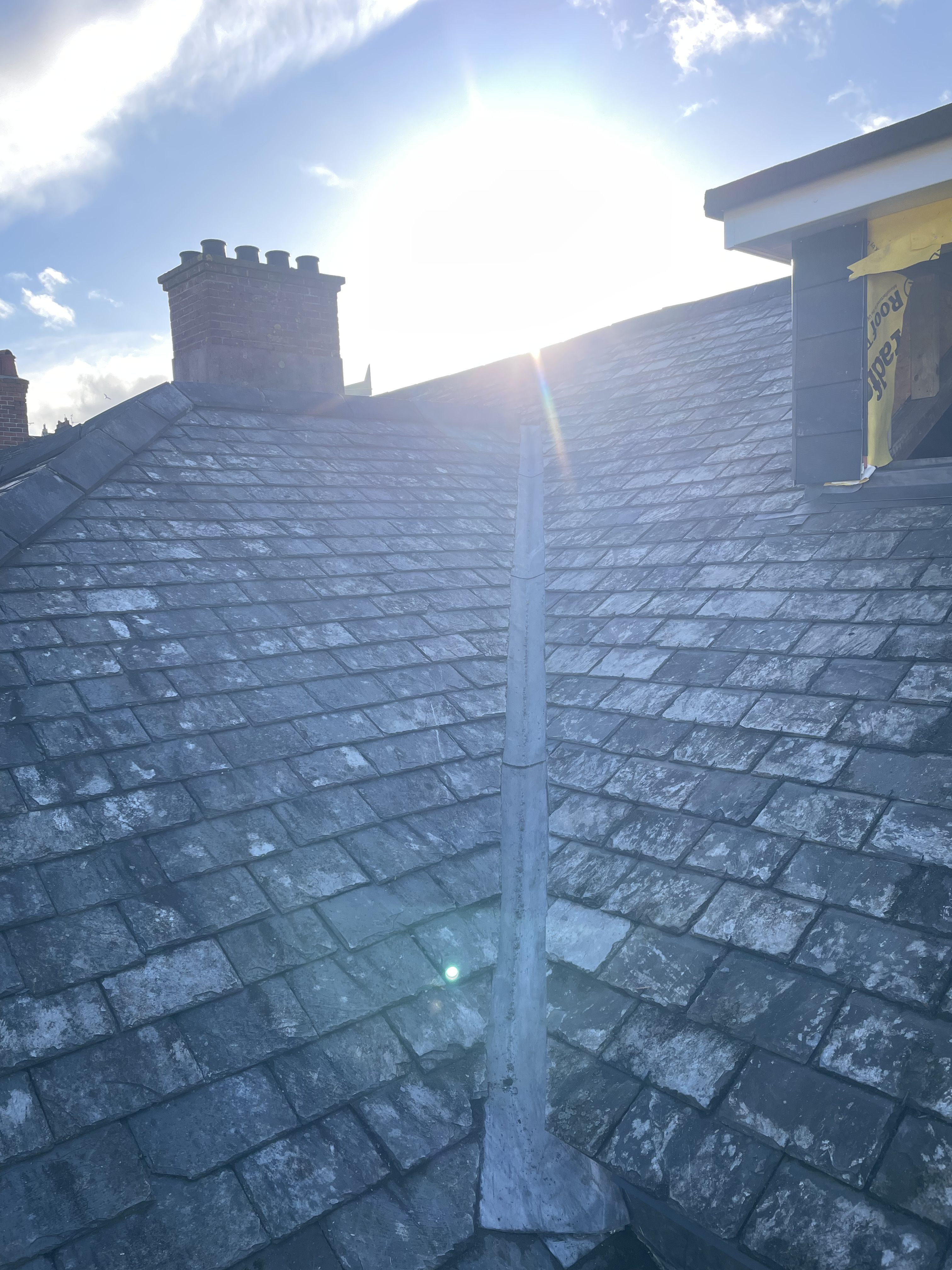 Bespoke lead roll detail on a traditional reclaimed Delabole slate ridge in Totnes, Devon, demonstrating heritage roofing techniques and maritime weatherproofing.