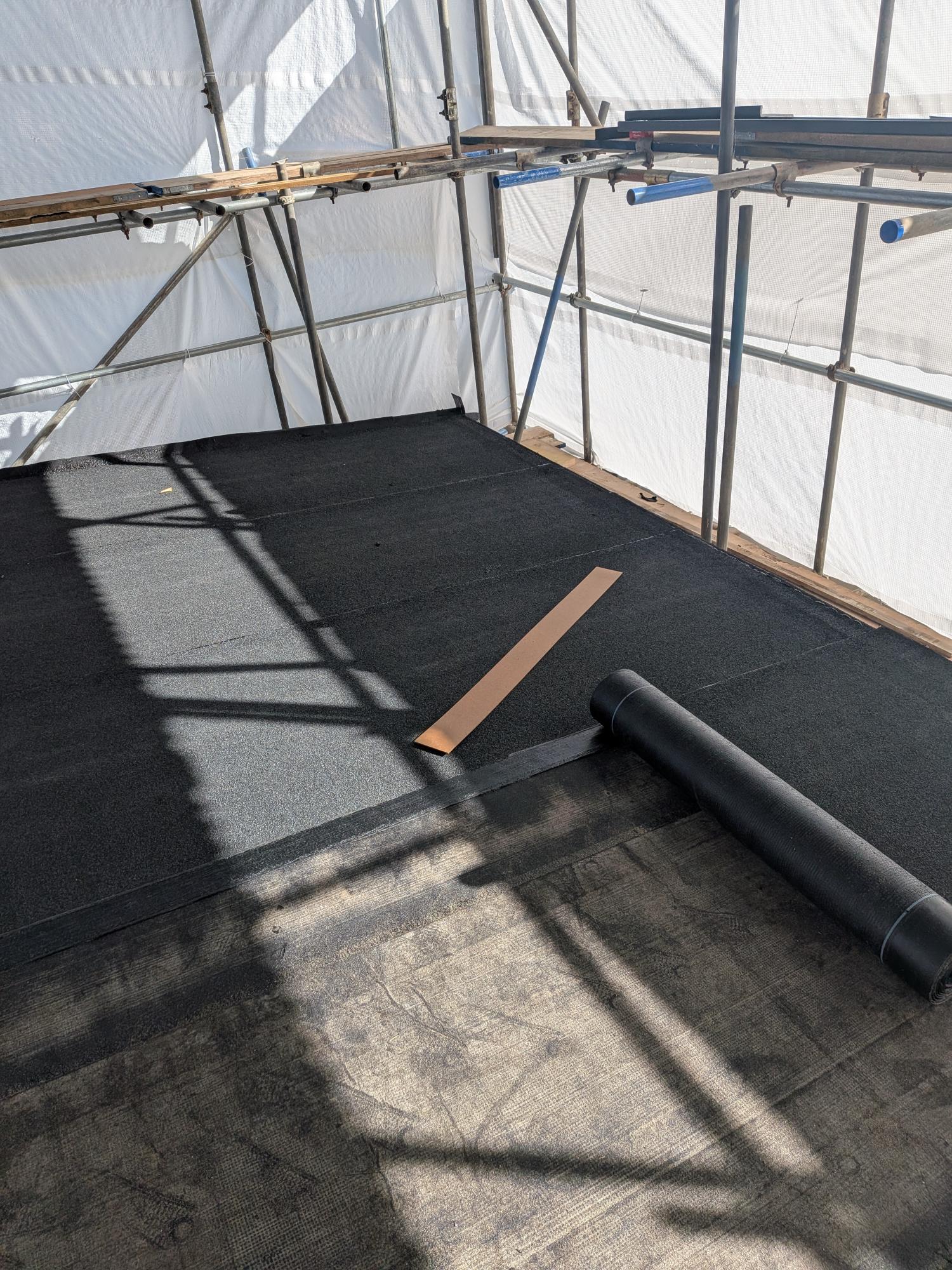 Torching on the primary waterproof felt layer over a structurally graded OSB3 timber flat roof deck