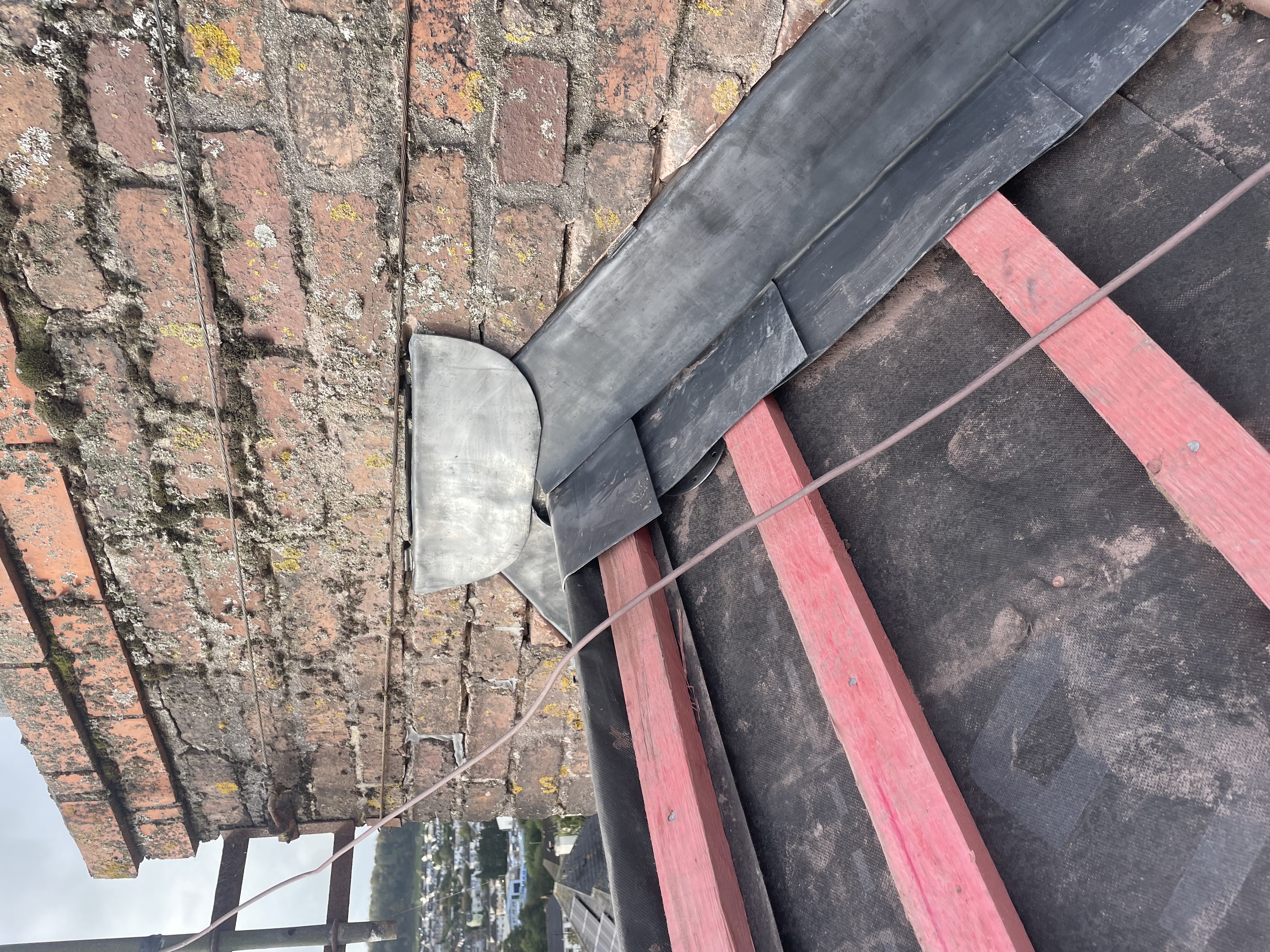 Close-up of expertly installed stepped lead flashing around a chimney in Plymouth.