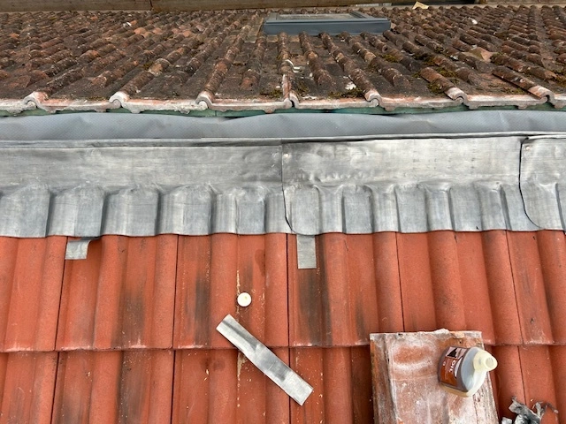 Detailed, traditional leadwork creating a weatherproof seal around a dormer window on a period property in Totnes.