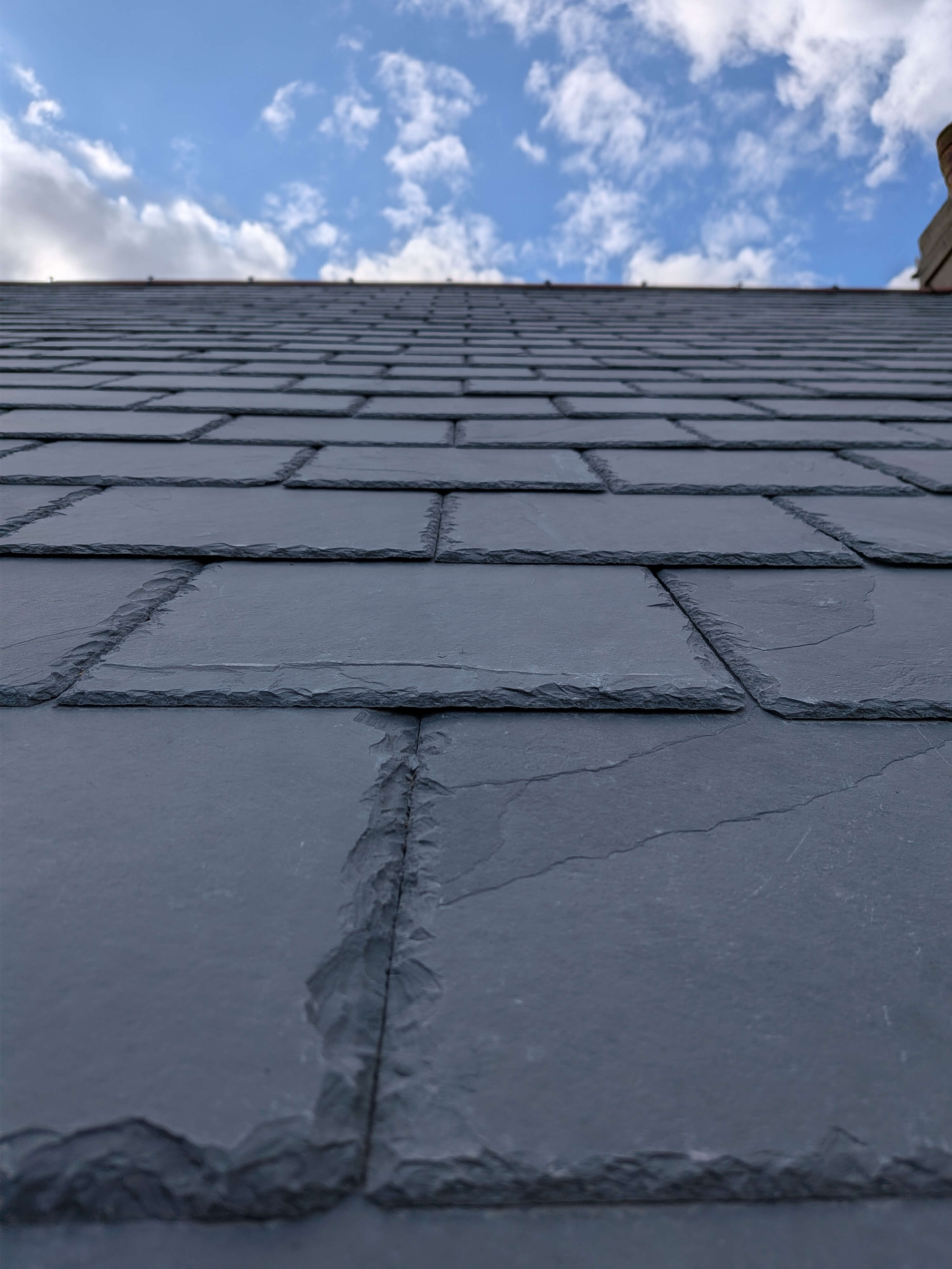 Detailed low-angle view of overlapping Brazilian slates demonstrating severe weather resistance and exact gauge alignment for properties in Torquay.