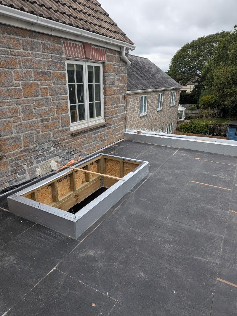 150mm PIR rigid insulation fitted tightly around raised skylight upstand on flat roof in Torbay